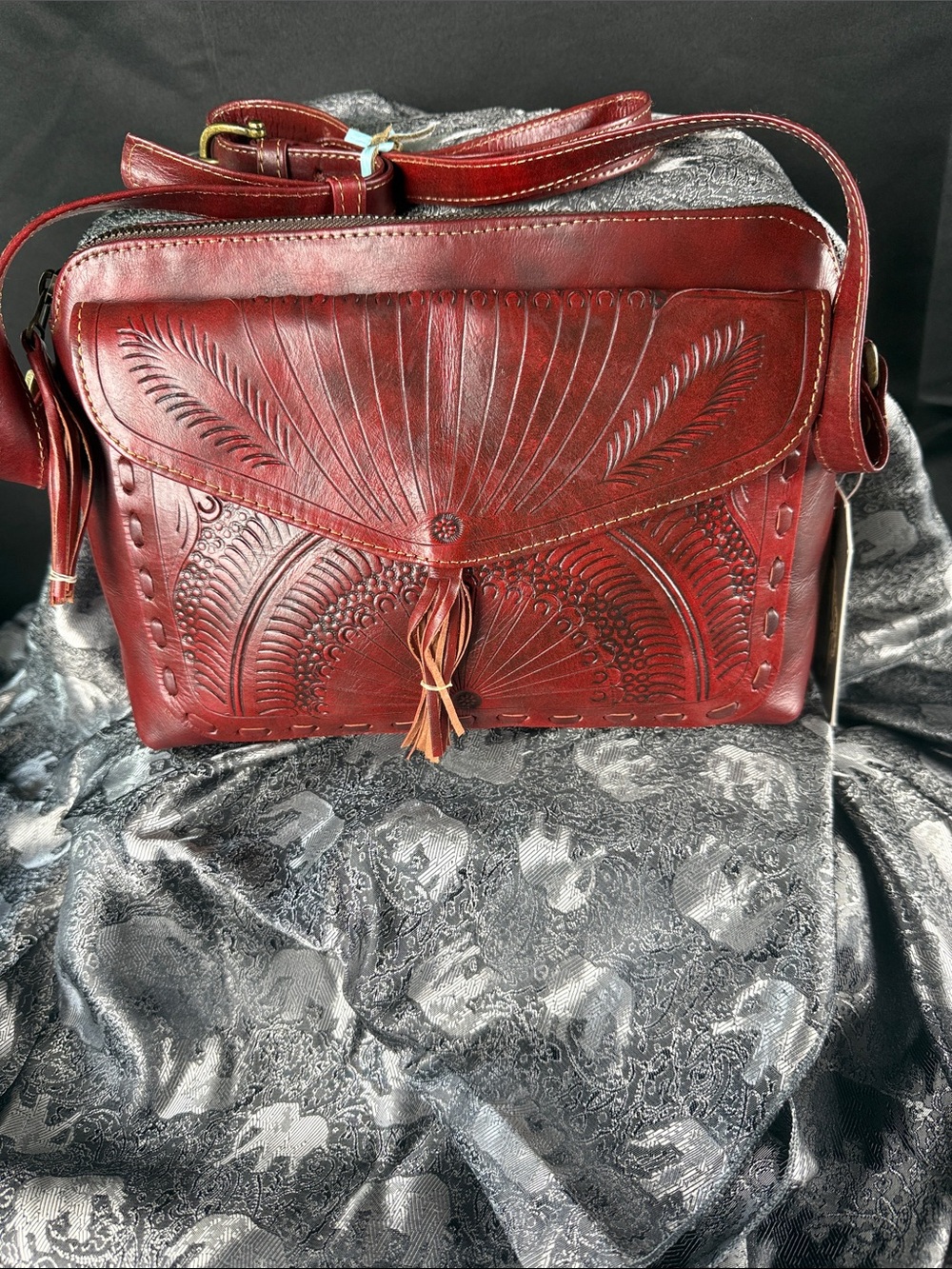 Hand-Tooled Burgundy Leather Crossbody Bag with Tassel Accent